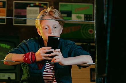 Pojke som tittar ner i sin mobil